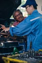 Gargae customer and car mechanic together investigate maintenance and repair programe at garage and car maintenance station Royalty Free Stock Photo