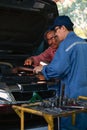 Gargae customer and car mechanic together investigate maintenance and repair programe at garage and car maintenance station Royalty Free Stock Photo