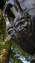 Gargoyle faces on cast iron urn