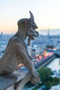 Gargoyle watching Eiffel tower and Paris at dusk Royalty Free Stock Photo