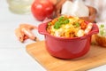 Garides Saganaki, prawns baked with cheese and vegetables in a red pot. Greek national cuisine. Close-up, selective