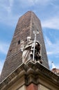 Garisenda tower and the statue in Bologna Royalty Free Stock Photo