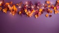 A garland of autumn leaves and light bulbs on a dark purple background.