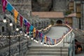 Garland of colorful flags and glowing light bulbs against a defocused background of castle Royalty Free Stock Photo