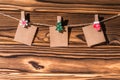 Garland with cute empty little kraft paper stickers hanging on a rope on wooden clothespins. Rustic Christmas decoration.
