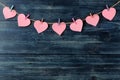 A garland of hearts on clothespins on a blue wooden background. view from above . space for text Royalty Free Stock Photo