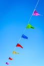 Garland of multicolored party flags against blue sky Royalty Free Stock Photo