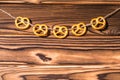 Garland of pretzels Salted Cookies hanging on a rope. Rustic Christmas decoration. Wooden boards background