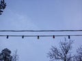 Garland of the switched-off multi-colored bulbs against the cloudy sky Royalty Free Stock Photo