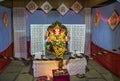 Garlanded deity idol of Lord Ganesha installed with background decorations for festival