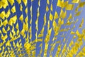 Garlands of yellow holiday flags fluttering in the wind against a bright blue summer sky. The concept of a festive holiday, annive Royalty Free Stock Photo
