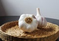 Garlic bulbs in a wicker basket on the black table with white background. Royalty Free Stock Photo