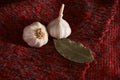 Garlic, bay leaf, black pepper on a red textile. Food background. Garlics. sliced garlic, garlic clove, garlic bulb.