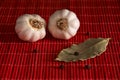 Garlic, bay leaf, black pepper on a red wooden table. Food background. Garlics. sliced garlic, garlic clove, garlic bulb.