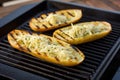 garlic bread on grilling tray with grill marks and dripping butter