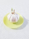 Garlic bulb in neon yellow plate