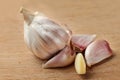 Garlic bulb, some of cloves separated, and one peeled, on old cu