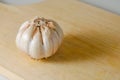 Garlic bulb on a wooden cutting board