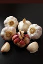 Garlic bulbs and cloves on the black surface. Brazilian spice Royalty Free Stock Photo