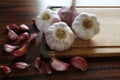 Garlic bulbs and cloves on the cutting board. Wooden table Royalty Free Stock Photo