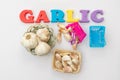 Garlic bulbs and cloves isolated on white background. Garlic word written on magnetic plastic letters on white isolated background Royalty Free Stock Photo