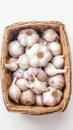 Garlic bulbs neatly arranged in wicker basket on white background Royalty Free Stock Photo