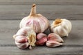 Garlic bulbs, with some purple cloves on gray wood table.