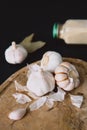 Garlic bulbs on a wooden board on a black background, with dried garlic. Condiments and spices in the kitchen.