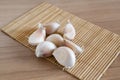 Garlic cloves on makisu mat on wood texture Royalty Free Stock Photo