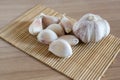 Garlic cloves on makisu mat on wood texture Royalty Free Stock Photo