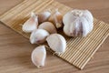 Garlic cloves on makisu mat on wood texture Royalty Free Stock Photo