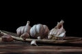 Fresh garlic bulbs and a garlic press on an old wooden board and a burlap backing Royalty Free Stock Photo