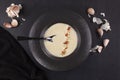 Garlic cream soup in black plate over dark background from above Royalty Free Stock Photo