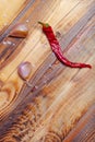 Garlic and dry red pepper on burned wooden table. Preparing for traditional rural dinner