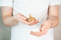 Garlic and fermented garlic in man`s hands. A man in a white t-shirt on a grey background holds garlic and black garlic bulbs in Royalty Free Stock Photo