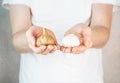 Garlic and fermented garlic in man's hands. A man in a white t shirt holds garlic and black garlic bulbs in Royalty Free Stock Photo