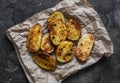 Garlic grilled potatoes on a dark background top view