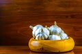 Garlic in hand turned hardwood bowl on a reclaimed hard wood background.