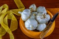 Garlic in hand turned hardwood bowl on a reclaimed hard wood background.