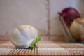 Garlic head with onions in the background Royalty Free Stock Photo