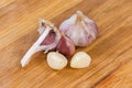 Garlic head and peeled and unpeeled cloves on cutting board