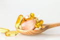 Garlic and oil capsule gel supplement in a wooden spoon Royalty Free Stock Photo