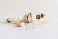 Garlic oil in capsules near whole bulb and cloves on a white table close up Royalty Free Stock Photo