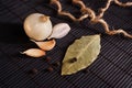 Garlic, onion, bay leaf, black pepper on black table. Food background. Garlics. sliced garlic, garlic clove, garlic bulb.