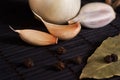 Garlic, onion, bay leaf, black pepper on black table. Food background. Garlics. sliced garlic, garlic clove, garlic bulb.