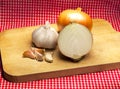 Garlic and onionon a table with a red tablecloth Royalty Free Stock Photo