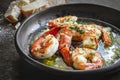 Garlic Prawns or Shrimp in black rustic bowl with crusty bread