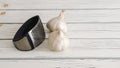 Garlic press and garlic cloves close-up on a white wooden background Royalty Free Stock Photo