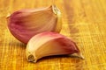 Garlic. Two Purple garlic cloves isolated on a wooden board Royalty Free Stock Photo