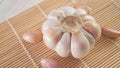 garlic bulb and cloves on a bamboo sushi mat Royalty Free Stock Photo
